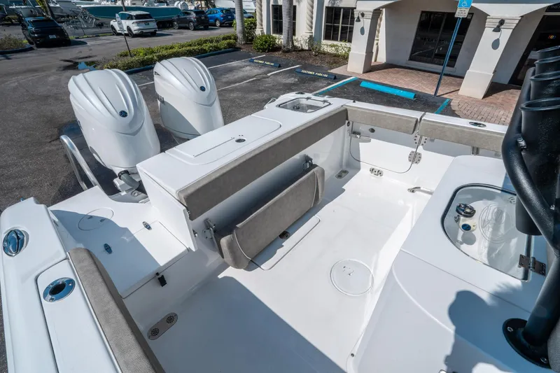 Slide: The Image of 2025 Sea Hunt Gamefish 25 boat interior with dual engines and seating in a marina setting. - 12