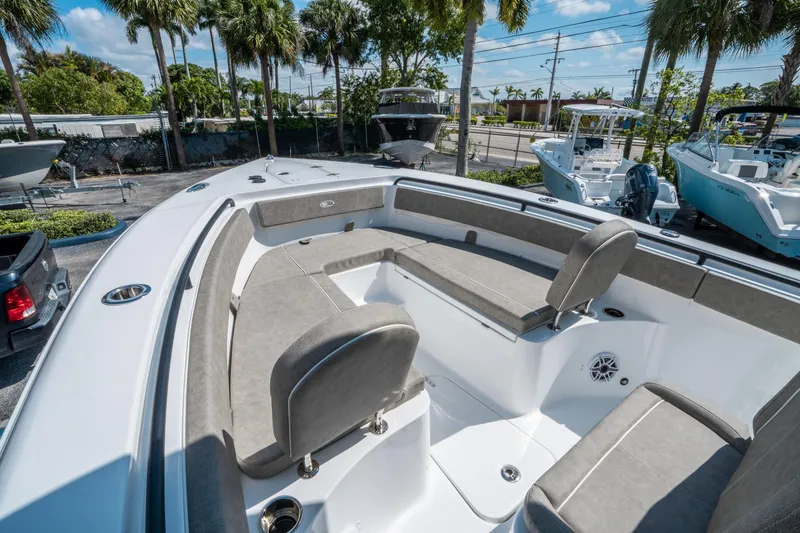Slide: The Image of 2025 Sea Hunt Gamefish 25 boat interior with cushioned seating and palm trees in the background. - 26