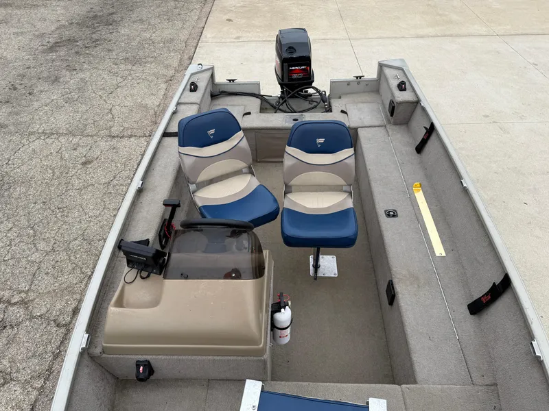 Slide: The Image of 1989 Fisher 16 Pro Avenger SC boat interior with blue seats and motor. - 10