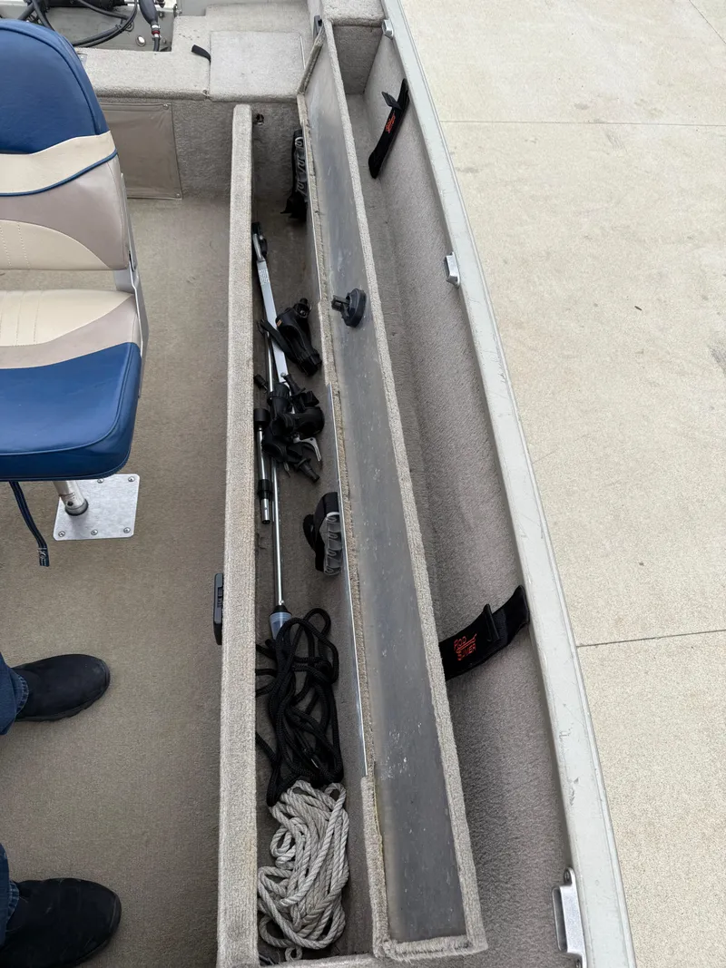 Slide: The Image of 1989 Fisher 16 Pro Avenger SC boat storage compartment with ropes and equipment. - 12