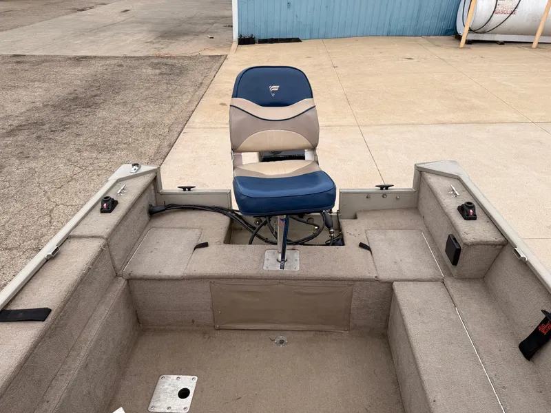 Slide: The Image of 1989 Fisher 16 Pro Avenger SC boat interior with blue and beige seating. - 18