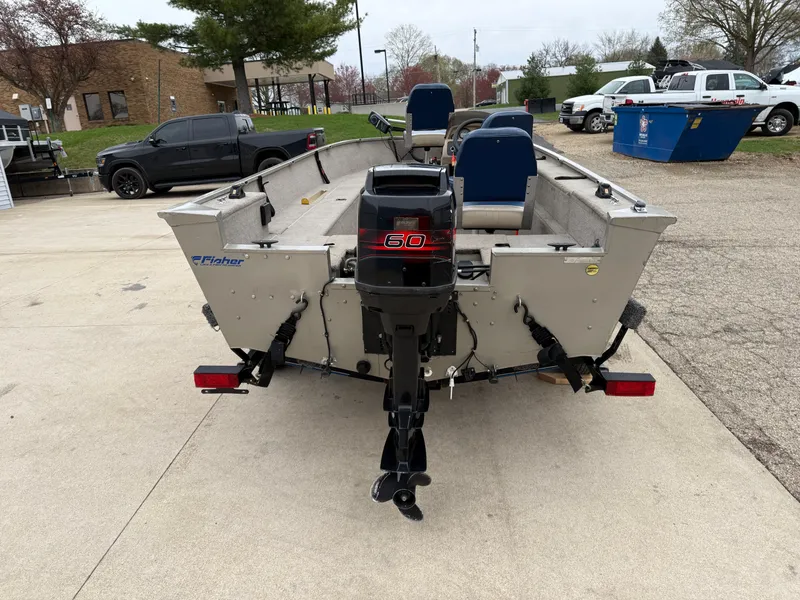 Slide: The Image of 1989 Fisher 16 Pro Avenger SC boat with outboard motor, parked outdoors. - 6