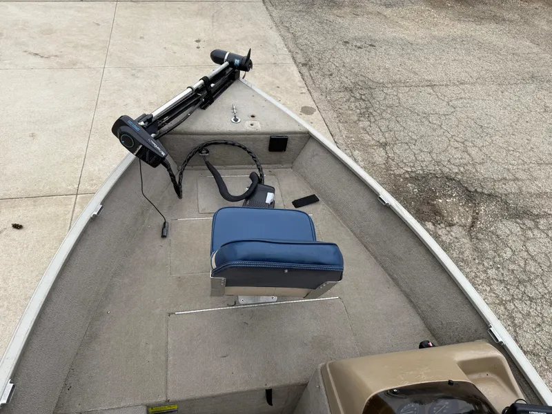 Slide: The Image of 1989 Fisher 16 Pro Avenger SC boat interior with blue seat and trolling motor. - 8