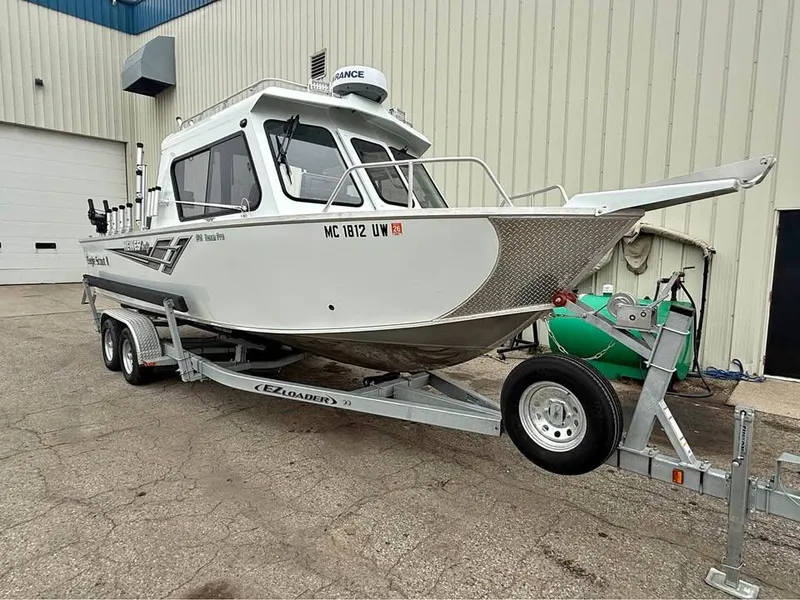 Slide: The Image of 2023 Hewescraft 240 Ocean Pro ET HT boat on trailer outside industrial building. - 3
