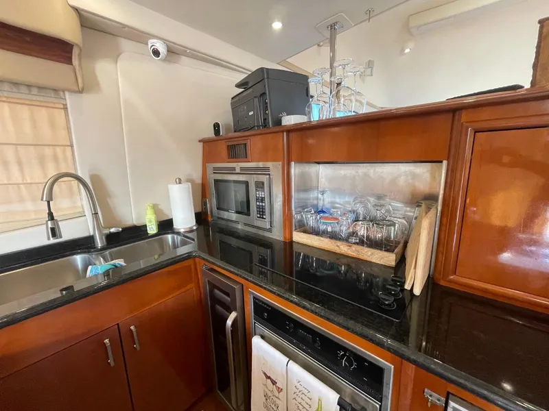 Slide: The Image of Kitchen area of a 2006 Carver 56 Voyager yacht with modern appliances and wooden cabinetry. - 29