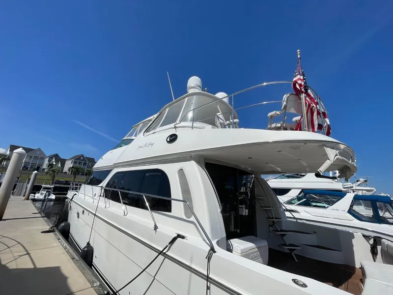 Slide: The Image of 2006 Carver 56 Voyager yacht docked, featuring sleek design and American flag. - 6