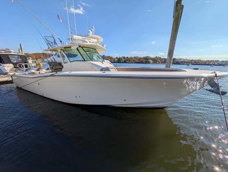 The Image of 2012 Grady-White Canyon 366 boat docked on calm water under clear blue sky. - 0