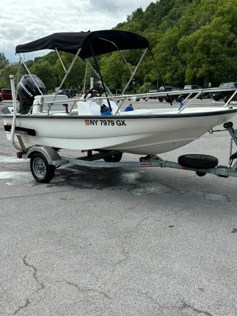 Slide: The Image of 2007 Boston Whaler 130 Sport boat on trailer with canopy, parked outdoors. - 4
