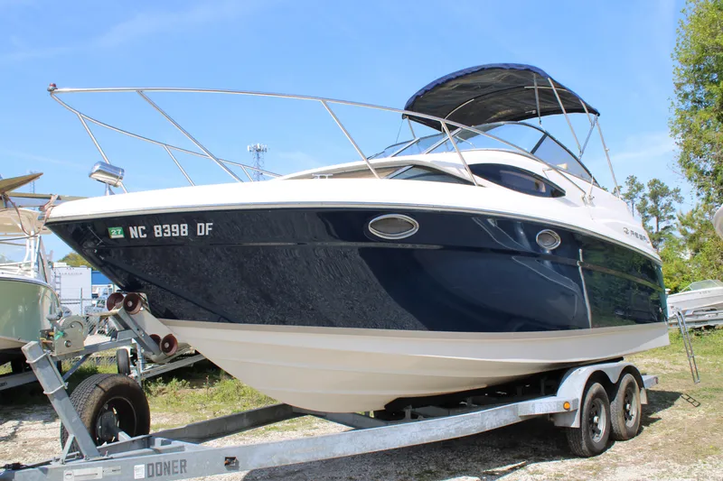 Slide: The Image of 2006 Regal 2565 Window Express boat on trailer, blue and white exterior, sunny day. - 0