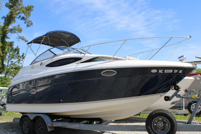 Slide: The Image of 2006 Regal 2565 Window Express boat on trailer, blue and white exterior, sunny day. - 1