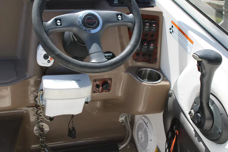 Slide: The Image of 2006 Regal 2565 Window Express boat cockpit with steering wheel and controls. - 19