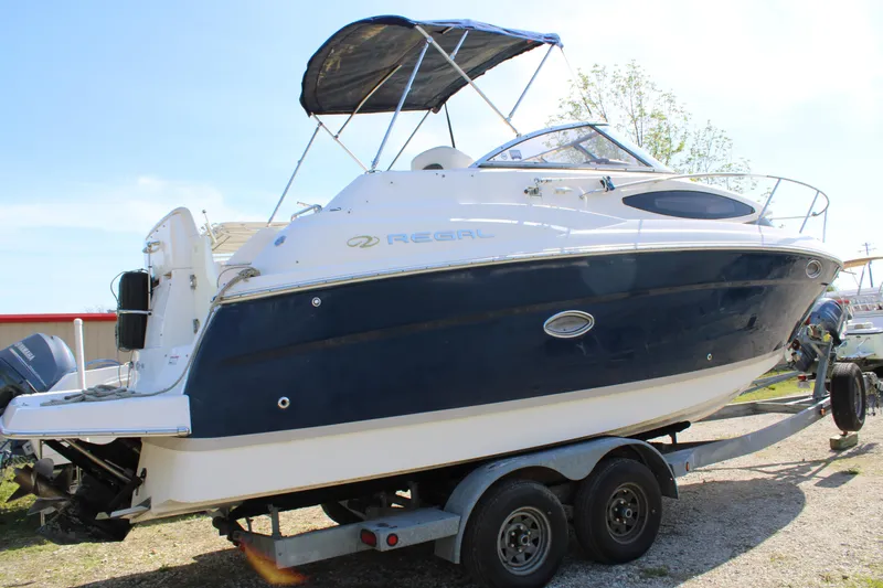 Slide: The Image of 2006 Regal 2565 Window Express boat on trailer, featuring sleek design and blue hull. - 2