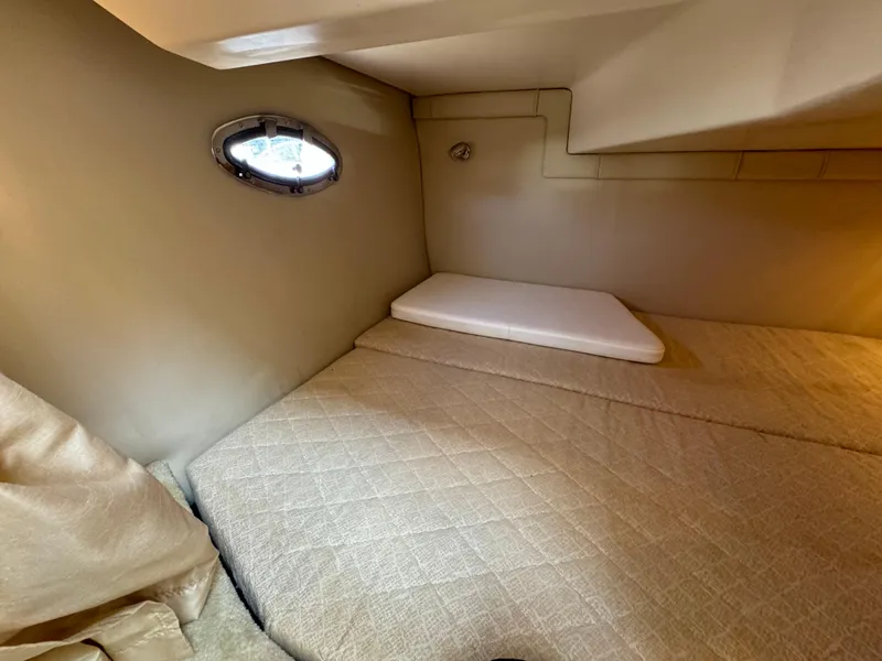 Slide: The Image of 2006 Regal 2565 Window Express cabin interior with bed and porthole. - 24
