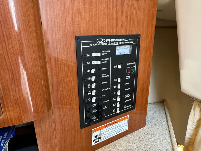 Slide: The Image of Control panel of a 2006 Regal 2565 Window Express boat, featuring various switches and indicators. - 26