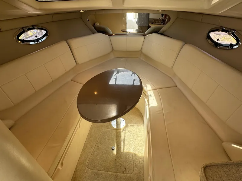 Slide: The Image of Interior of 2006 Regal 2565 Window Express boat with beige seating and oval table. - 30