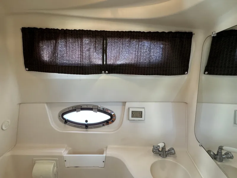 Slide: The Image of Interior of 2006 Regal 2565 Window Express boat bathroom with sink and window. - 35