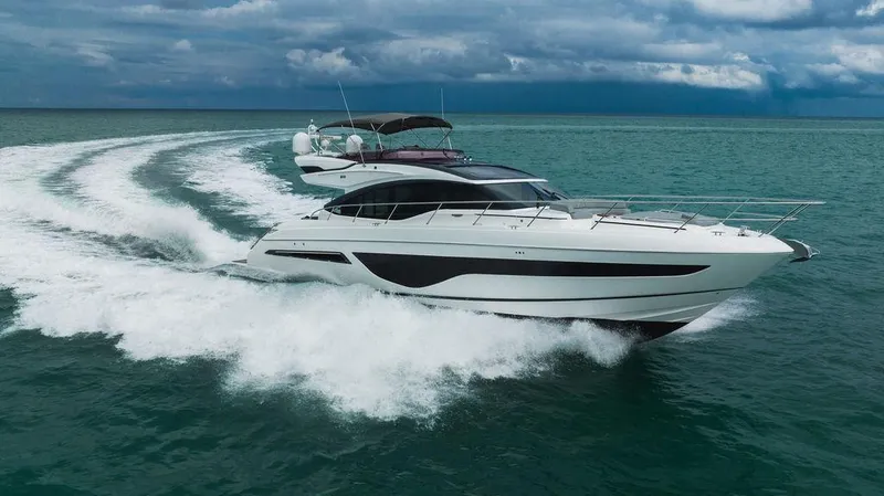 Slide: The Image of 2022 Princess S66 yacht cruising on open water under cloudy skies. - 23