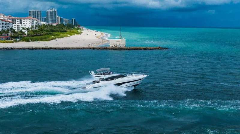 Slide: The Image of 2022 Princess S66 yacht cruising near a scenic coastline with turquoise waters. - 4