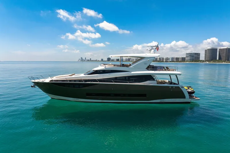 Slide: The Image of Luxurious 2015 Prestige 750 yacht cruising on clear blue waters near a city skyline. - 0