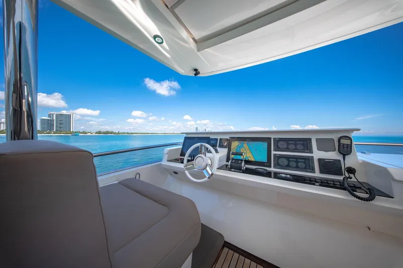 Slide: The Image of Helm of 2015 Prestige 750 yacht with navigation screens, overlooking ocean and skyline. - 10
