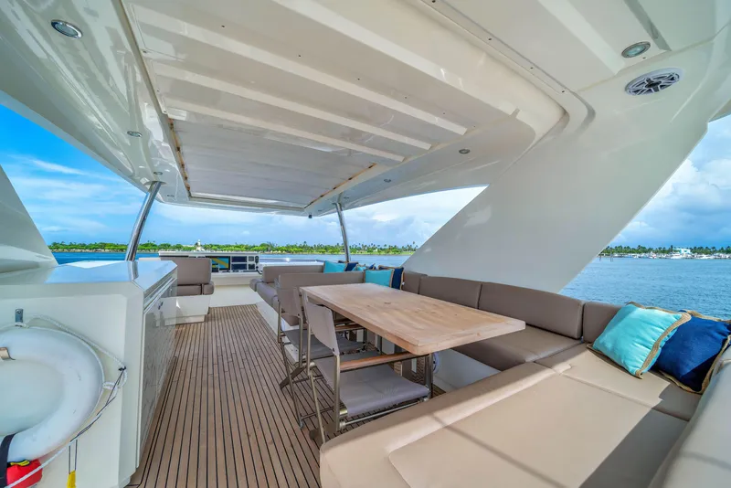Slide: The Image of Luxurious 2015 Prestige 750 yacht deck with seating, table, and ocean view. - 12