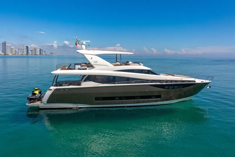 Slide: The Image of Luxury 2015 Prestige 750 yacht cruising near city skyline on calm ocean waters. - 2