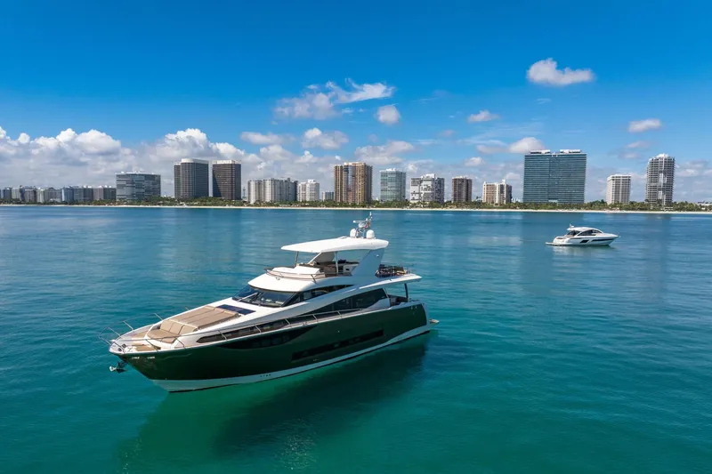Slide: The Image of Luxury 2015 Prestige 750 yacht on calm waters with city skyline backdrop. - 85