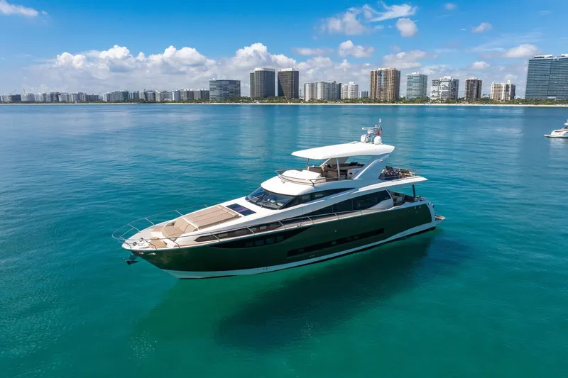 Slide: The Image of Luxurious 2015 Prestige 750 yacht cruising in clear blue waters near a city skyline. - 86