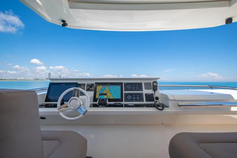 Slide: The Image of Helm of 2015 Prestige 750 yacht with navigation screens, steering wheel, and ocean view. - 9