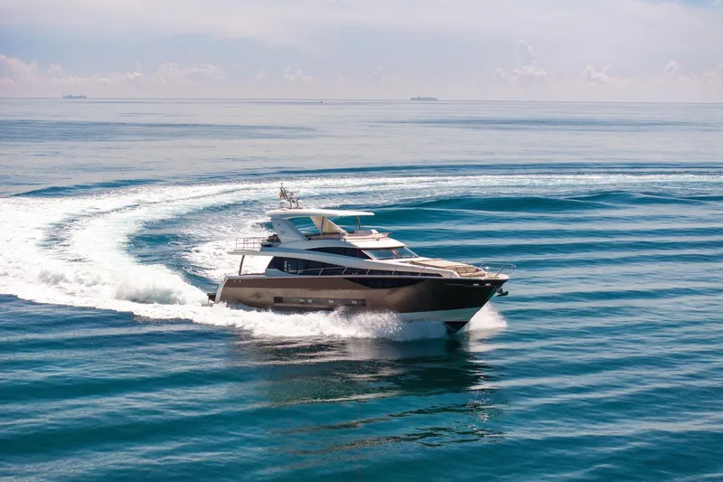 Slide: The Image of Luxury 2015 Prestige 750 yacht cruising on open sea, creating dynamic water trails. - 91