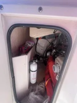 Slide: The Image of Storage compartment of 2002 Grady-White Escape 209 boat with safety equipment. - 12