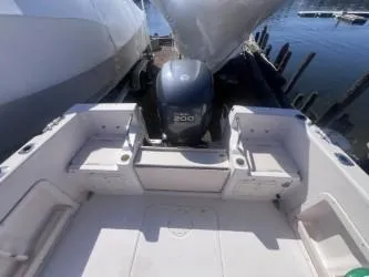 Slide: The Image of 2002 Grady-White Escape 209 boat interior with Yamaha 200 engine, docked by the water. - 4
