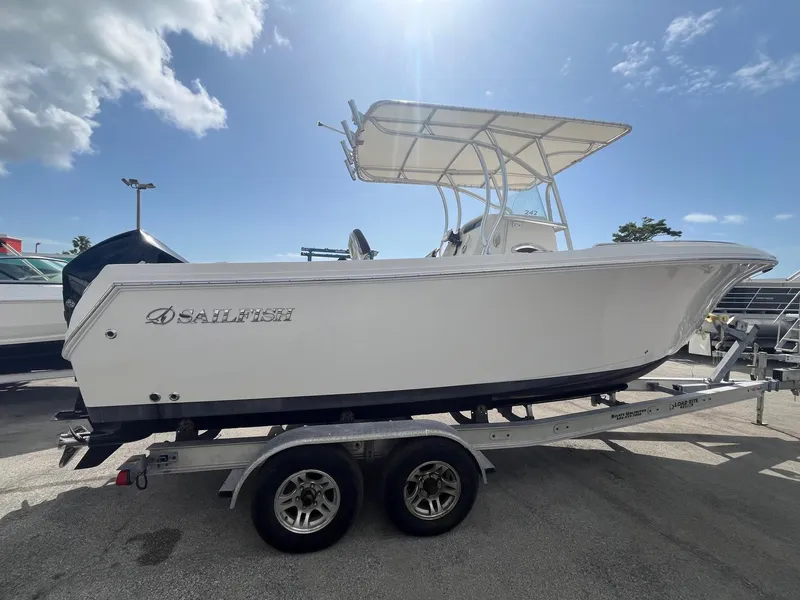 Slide: The Image of 2022 Sailfish 242 CC boat on trailer under clear sky. - 2