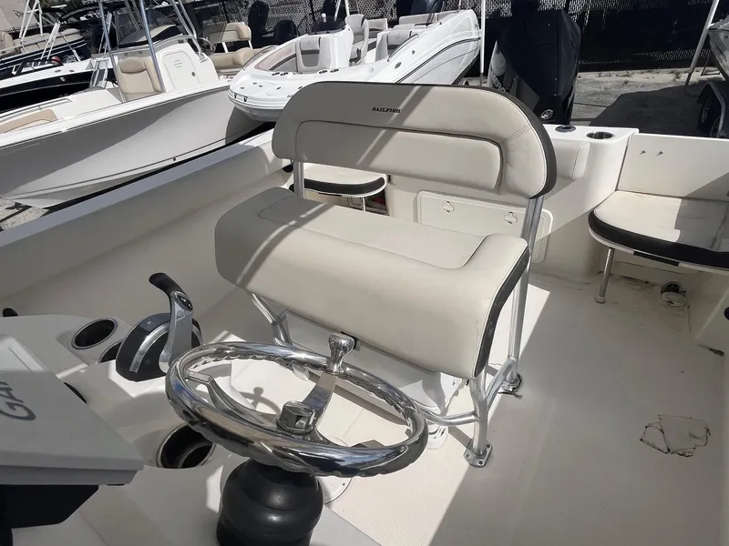 Slide: The Image of 2022 Sailfish 242 CC boat interior with steering wheel and seating. - 8