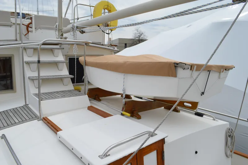 Slide: The Image of 1987 Grand Banks 36 Classic yacht deck with covered dinghy and metal stairs. - 25