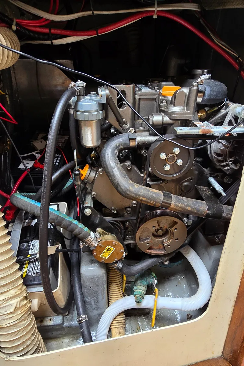 Slide: The Image of Engine compartment of a 1985 Mirage Yachts 35, showcasing mechanical components and wiring. - 11
