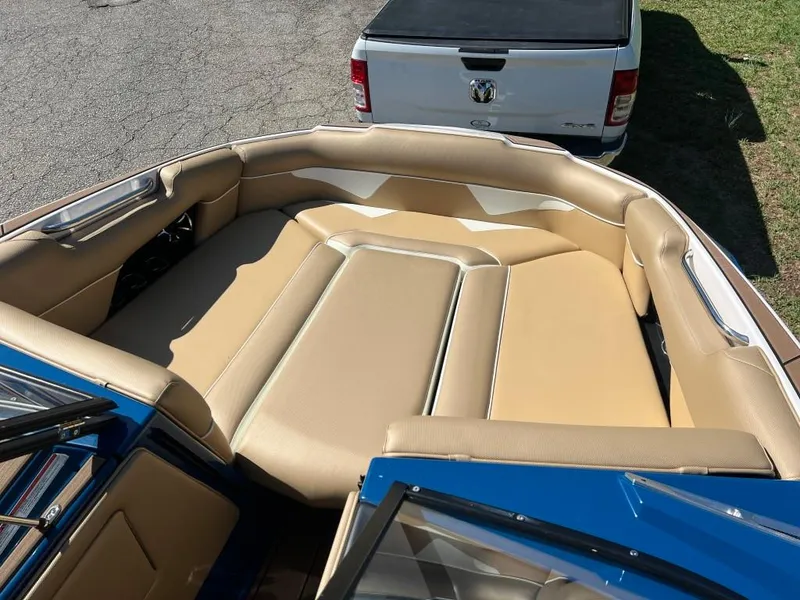 Slide: The Image of 2021 Moomba Makai boat with tan seating, parked near a white truck. - 10