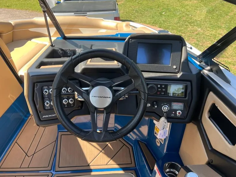 Slide: The Image of 2021 Moomba Makai boat dashboard with steering wheel and control panel. - 14