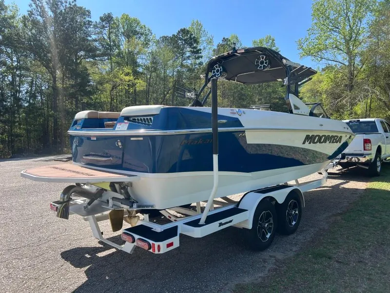 Slide: The Image of 2021 Moomba Makai boat on trailer, parked outdoors with trees in the background. - 5