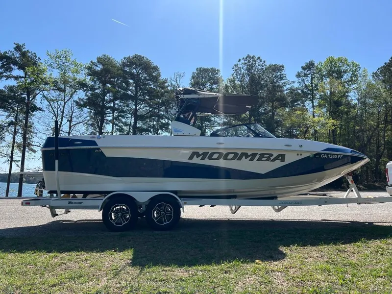 Slide: The Image of 2021 Moomba Makai boat on trailer, parked near a lake with trees in the background. - 6
