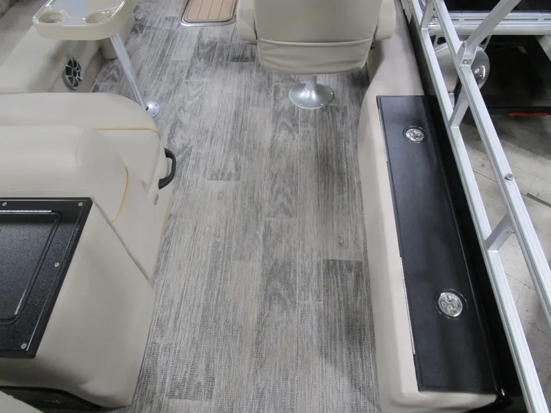 Slide: The Image of Interior of 2025 Ranger 223 FC boat with wood flooring and beige seating. - 11