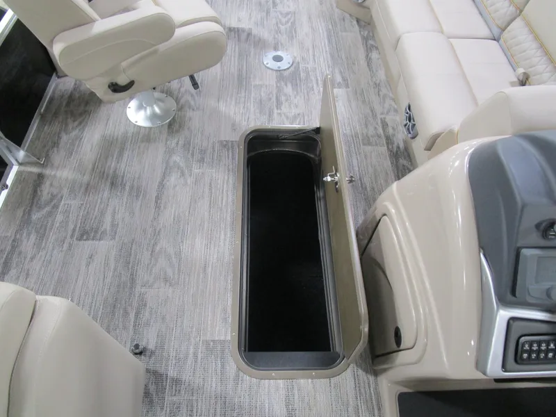 Slide: The Image of Interior of 2025 Ranger 223 FC boat with open storage compartment and beige seating. - 18