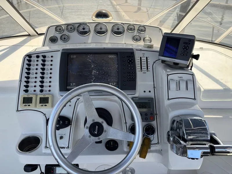 Slide: The Image of 2008 Fountain 33 Sportfish Cruiser helm with steering wheel, gauges, and navigation equipment. - 13