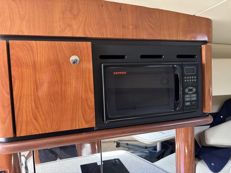 Slide: The Image of 2008 Fountain 33 Sportfish Cruiser interior with microwave and wooden cabinetry. - 18