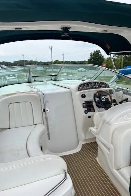 Slide: The Image of 2001 Sea Ray 290 Sundancer boat interior with white seating and control panel. - 10
