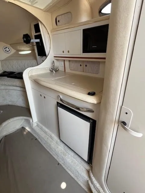 Slide: The Image of 2001 Sea Ray 290 Sundancer interior with kitchenette and compact fridge. - 3