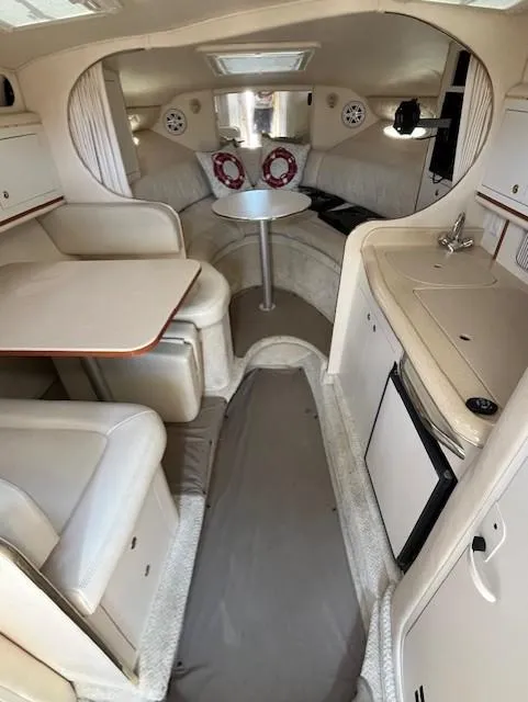 Slide: The Image of 2001 Sea Ray 290 Sundancer cabin interior with seating, table, and kitchenette. - 4