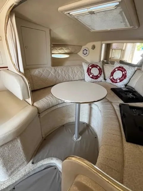 Slide: The Image of Interior of 2001 Sea Ray 290 Sundancer with cozy seating and round table. - 5