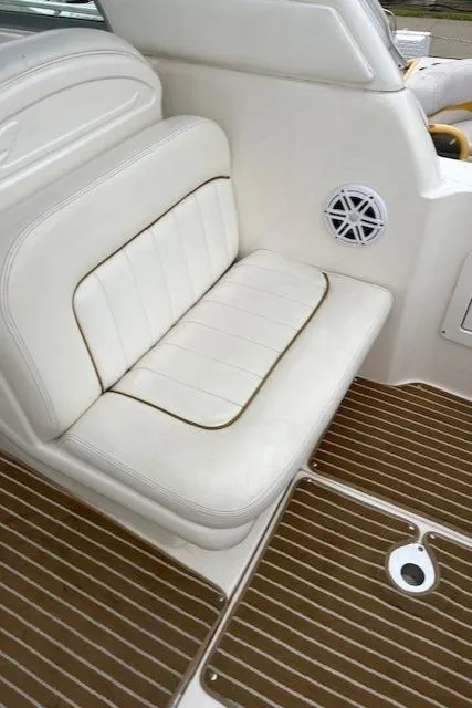 Slide: The Image of 2001 Sea Ray 290 Sundancer boat interior with white seating and wood-patterned flooring. - 8