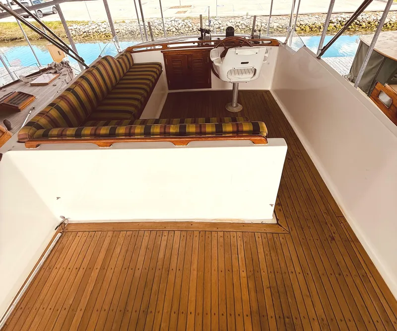 Slide: The Image of 1980 C & L Sea Ranger boat interior with striped seating and wooden flooring. - 14